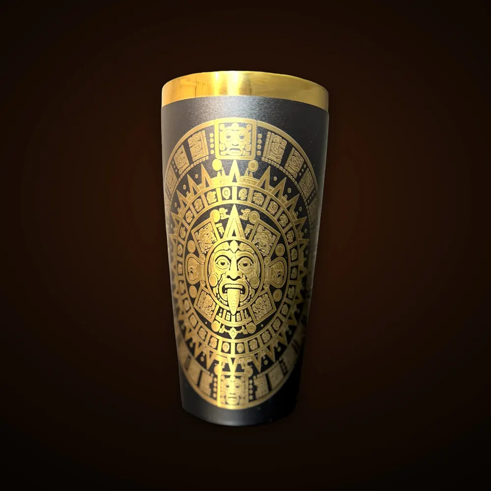 Black tumbler laser-engraved with a gold Aztec sun design